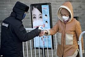 中国は繁華街でも歩行者の温度を計測するなど、新型コロナウイルスの感染拡大に警戒を強めている=AP