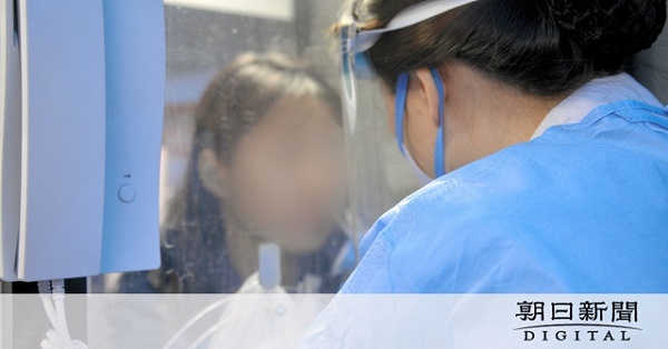 PCR検査を行うブースに入り、鼻から検体を採取される女性（左）=3月20日、ソウル、神谷毅撮影（画像を一部加工しています）